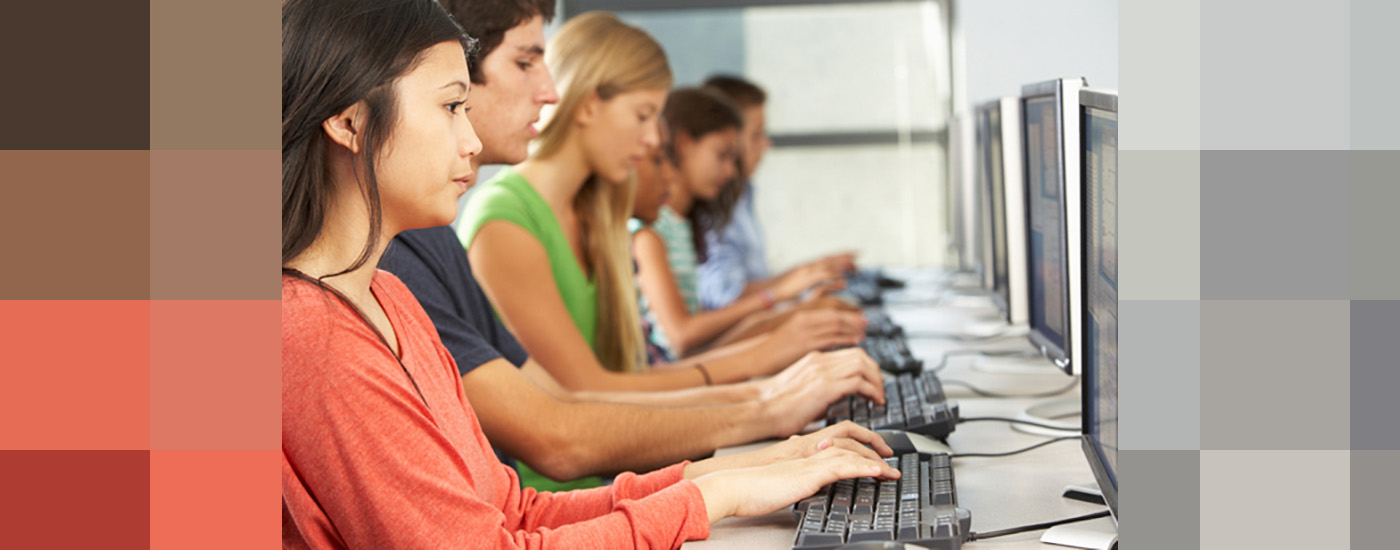 Concentrated students working on desktop computers.